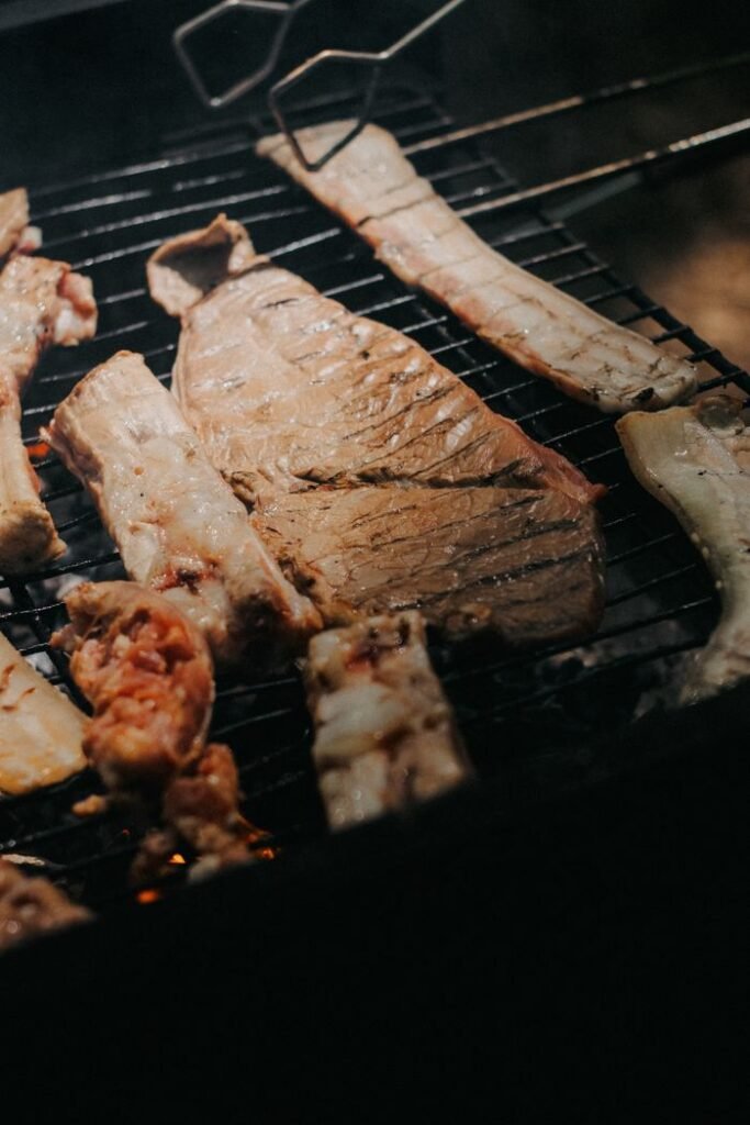 Close-up of various meats sizzling on a barbecue grill for a delicious meal.
