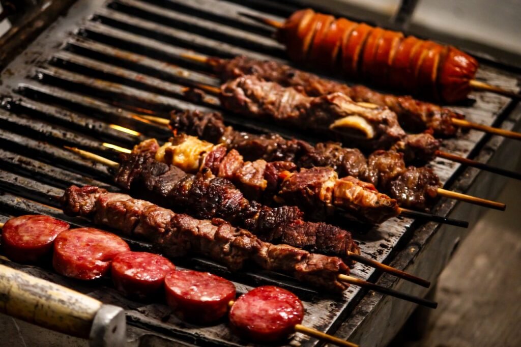 Delicious assortment of grilled meat skewers sizzling on the barbecue. Perfect for outdoor feasts.