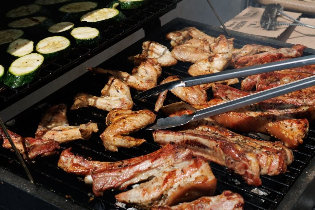 Delicious barbecue chicken and zucchini grilling outdoors on a sunny day.